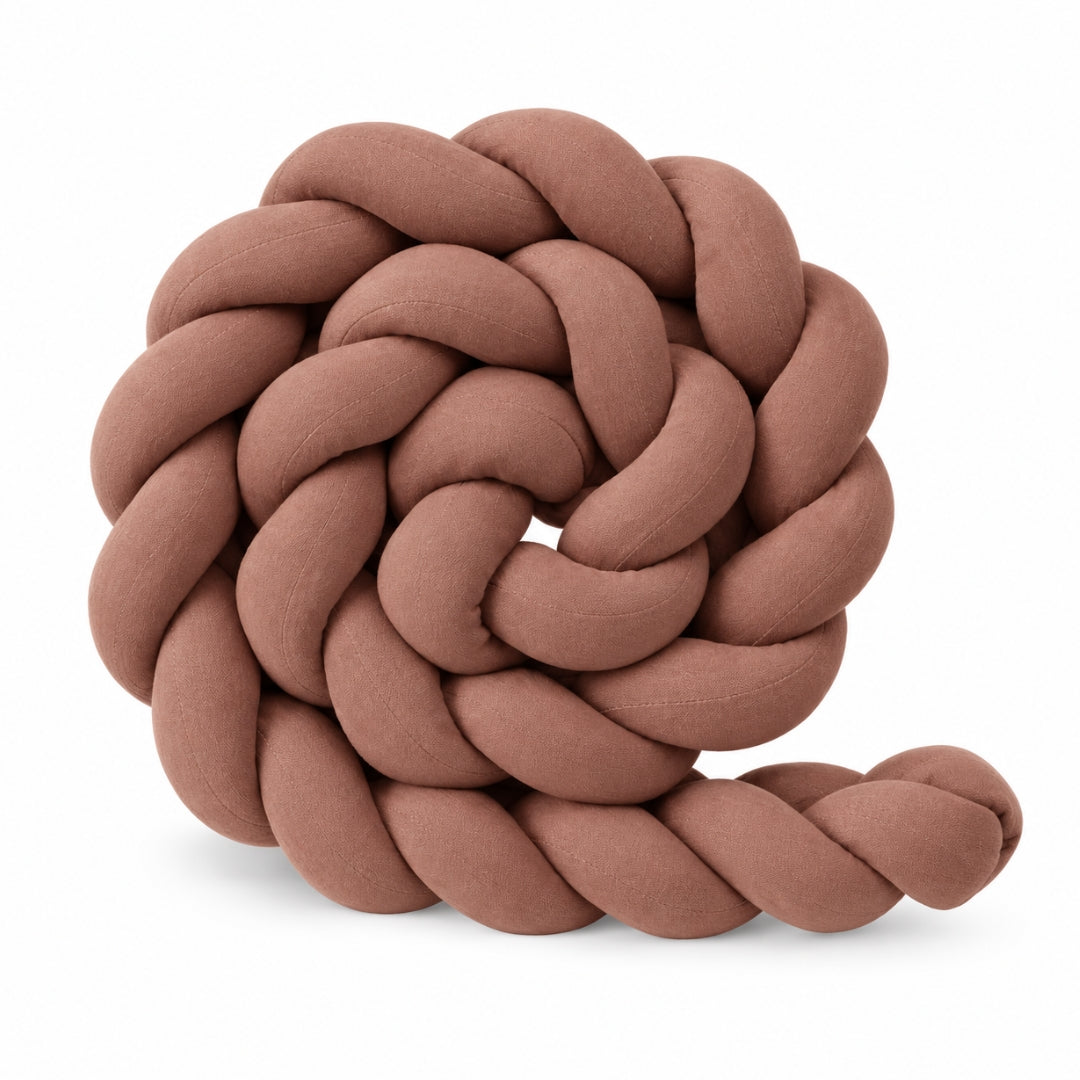 Tresse tour de lit bébé unie chocolat enroulée sur fond blanc