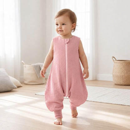 Bébé qui marche dans sa turbulette à jambes rose près d'un panier en osier