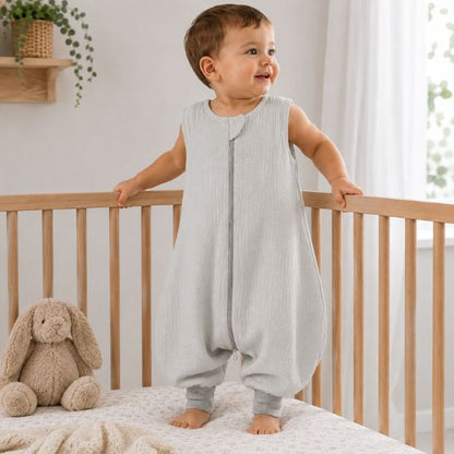 Turbulette à pieds gris chiné portée par un enfant debout dans son lit, peluche lapin au premier plan