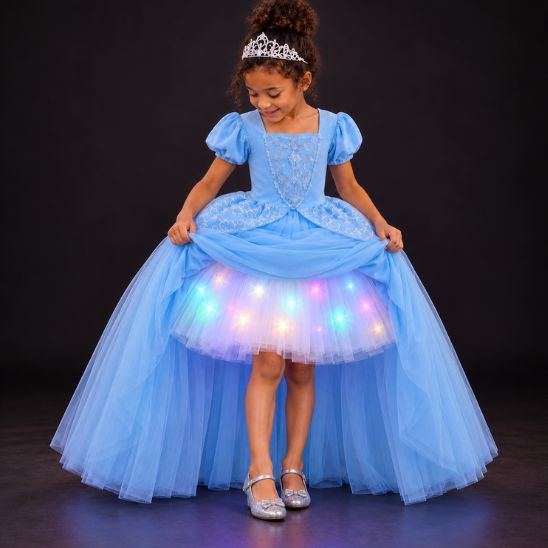 Fillette soulevant sa robe de princesse bleue pour montrer le tutu lumineux