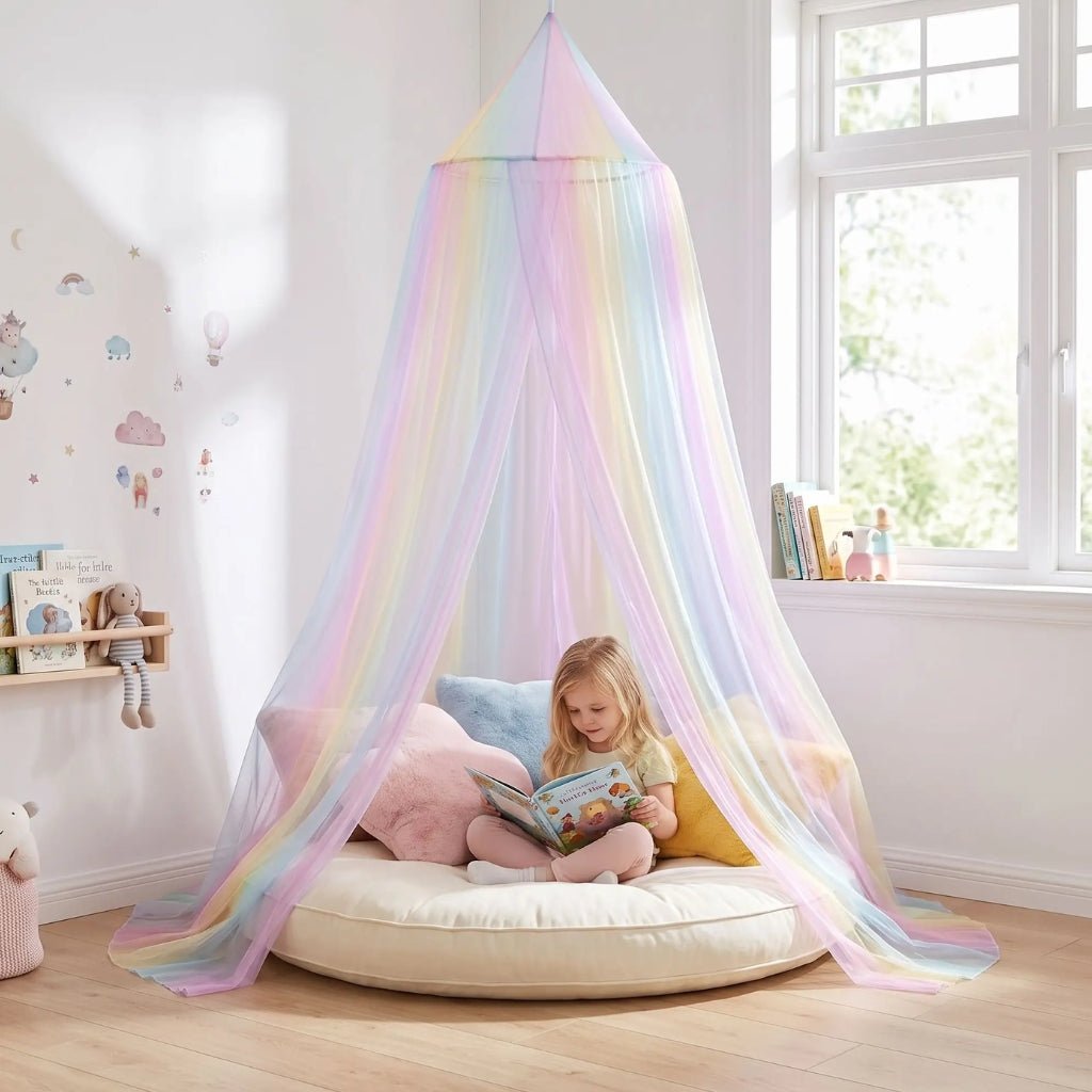 Petite fille qui lit sur un gros coussin sous un voile de lit arc-en-ciel en coin lecture